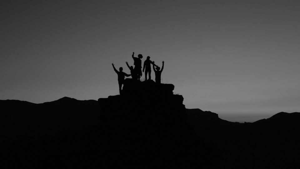Silhouetted group beneath a traditional hierarchical structure graphic