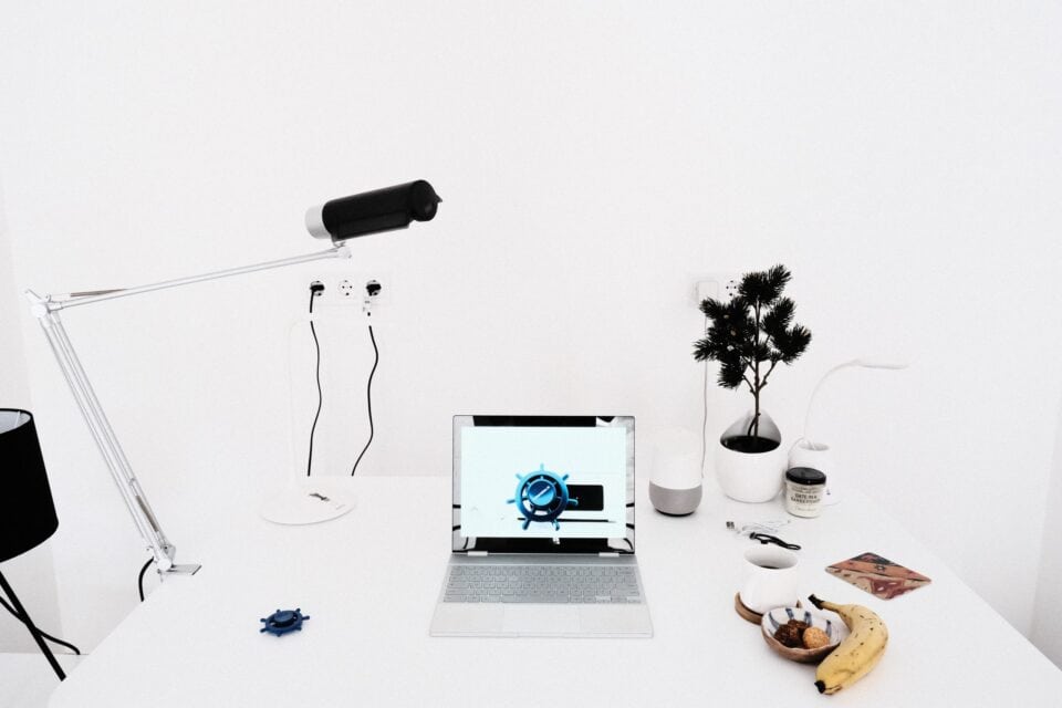 Minimal white desk with compact camera equipment and a small plant