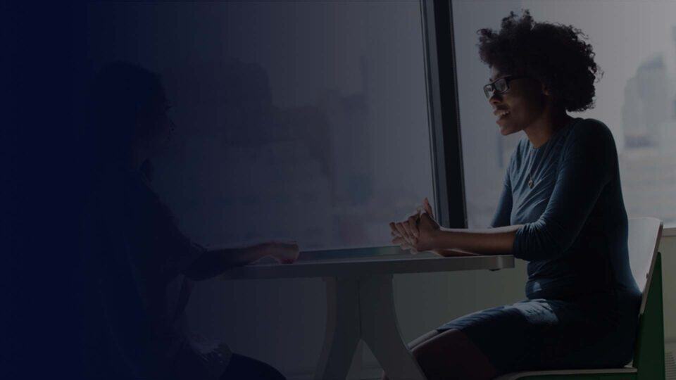 Professional working at a desk in a dark technology workspace