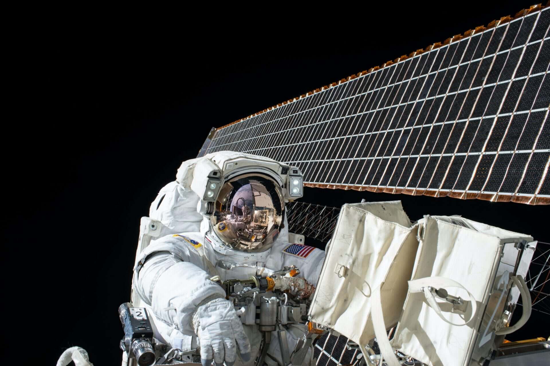 NASA satellite solar panels extending above Earth in orbit