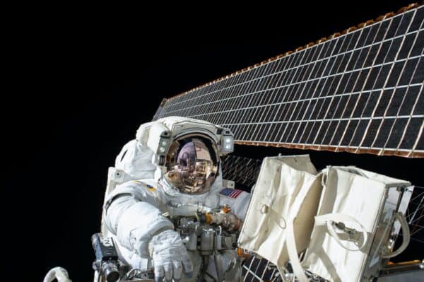 NASA satellite solar panels extending above Earth in orbit