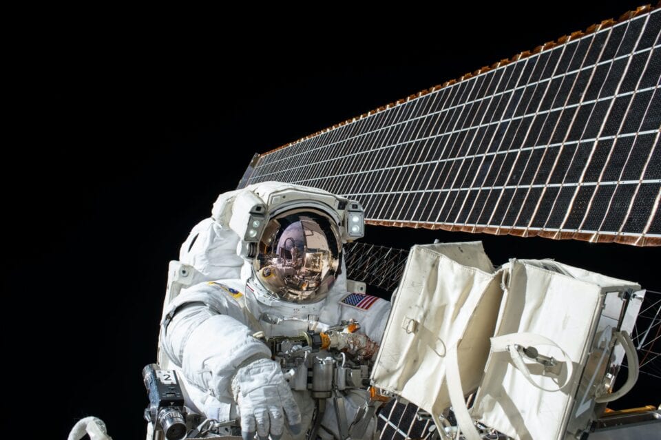 NASA satellite solar panels extending above Earth in orbit