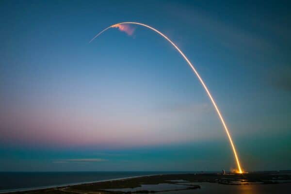 SpaceX rocket leaving a bright curved trail across the evening sky