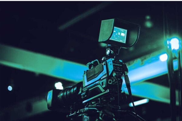Camera operator filming content with professional broadcast equipment