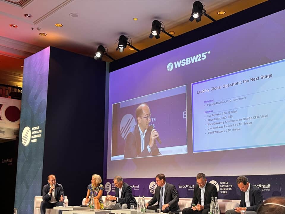 Speaker presenting on stage at a space industry conference