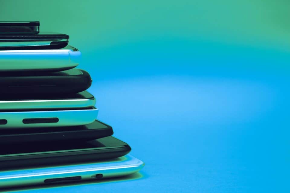 Stacked digital devices arranged on a blue connectivity background