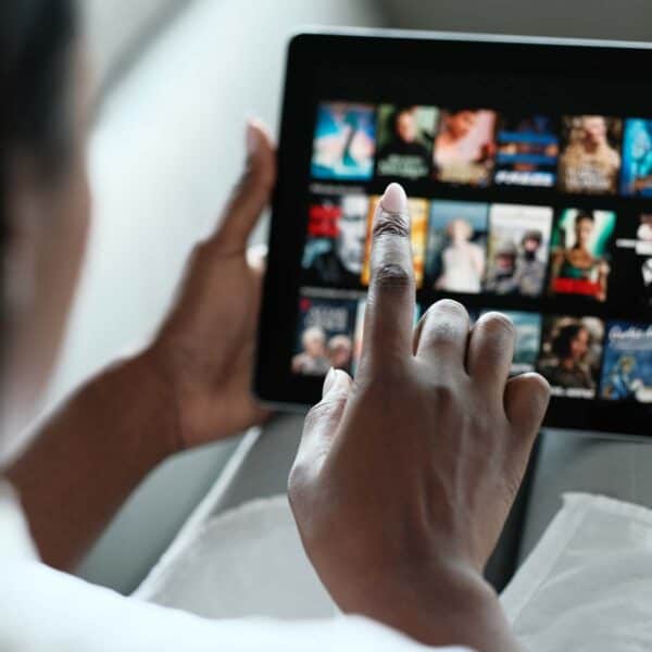 Hand browsing digital media content on a touchscreen tablet