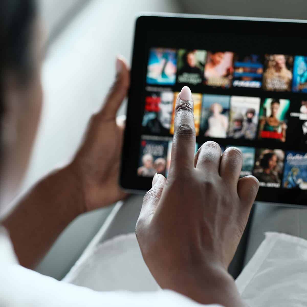 Hand browsing digital media content on a touchscreen tablet
