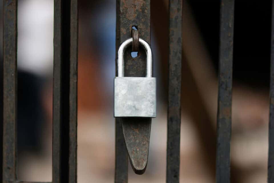 Metal padlock secured to a door representing cyber security protection
