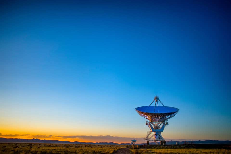 Satellite communications dish beneath a clear blue sky