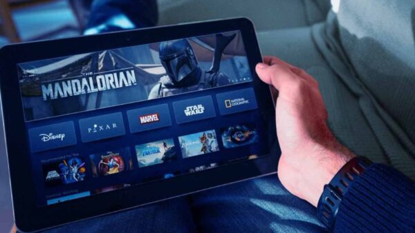 Person holding a tablet displaying a digital streaming interface