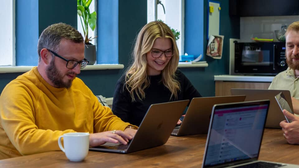 Two technology professionals working together on a laptop