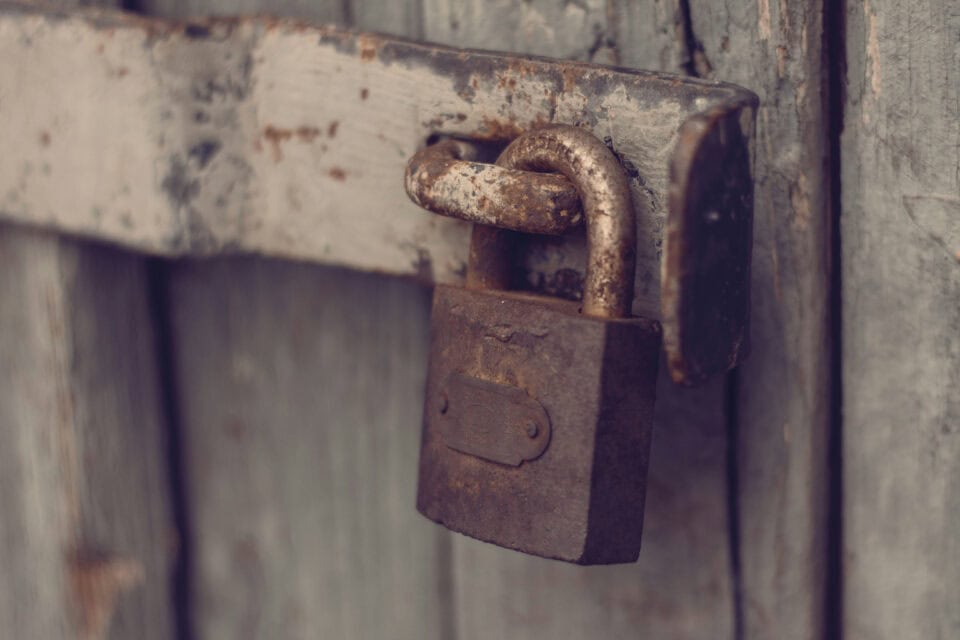 Weathered padlock on a wall representing cyber security protection