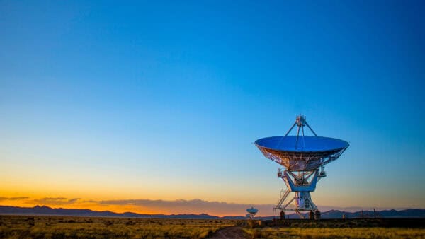 Satellite communications dish beneath a clear blue sky