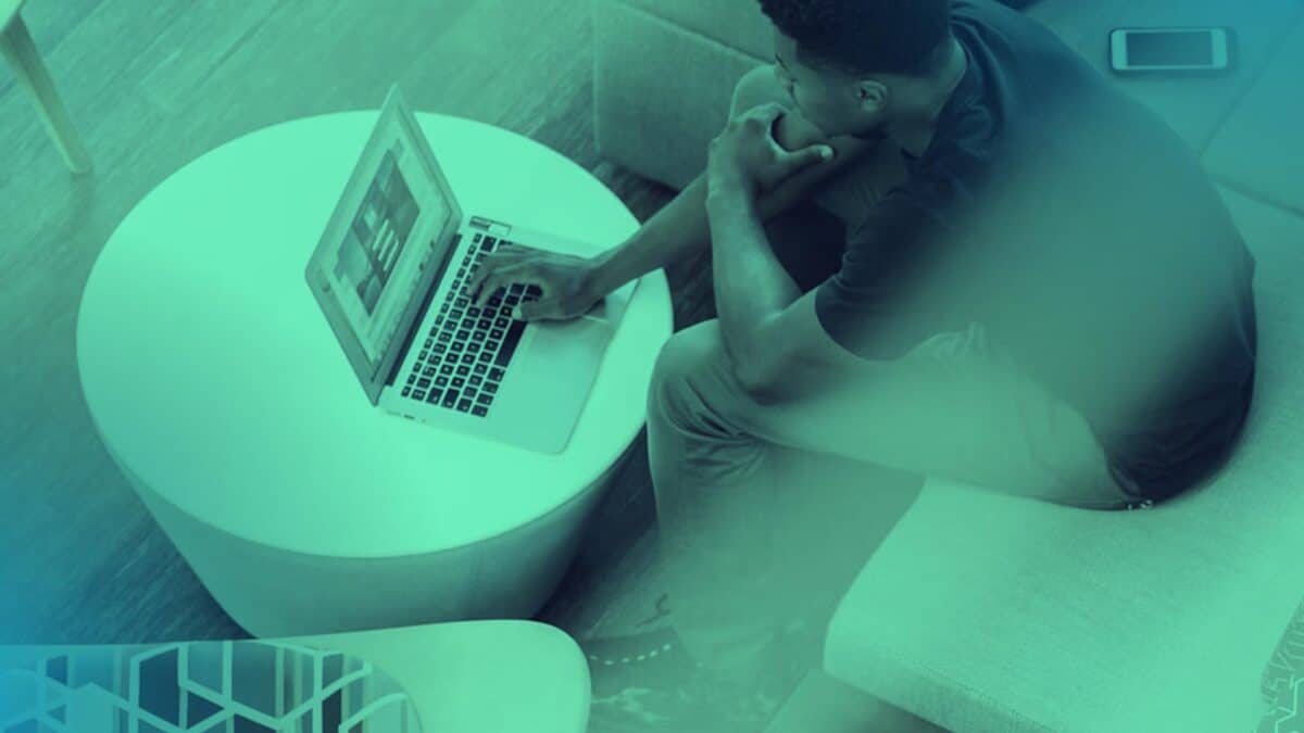 Hand using a smartphone beside a laptop for LinkedIn recruitment activity