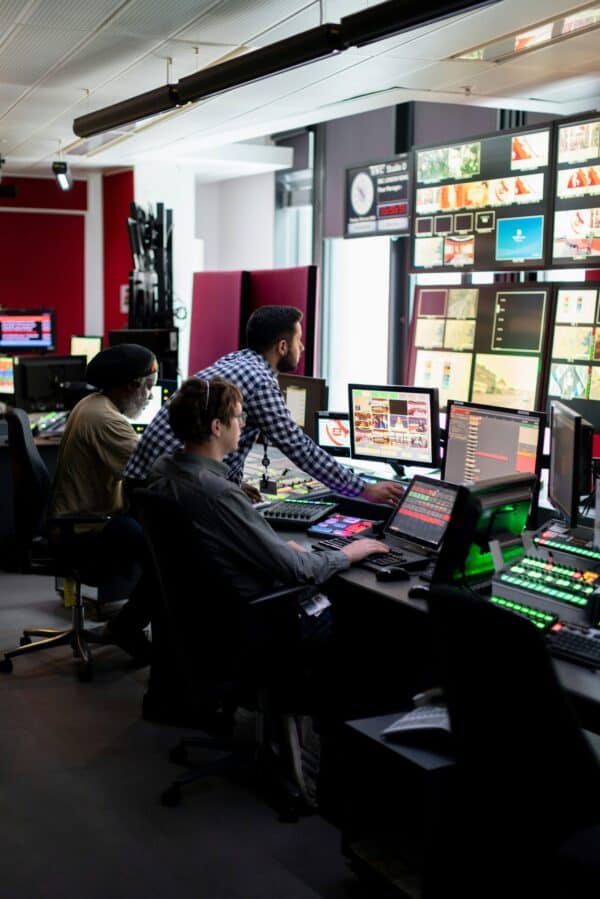 Broadcast production team monitoring live video feeds in a media control room