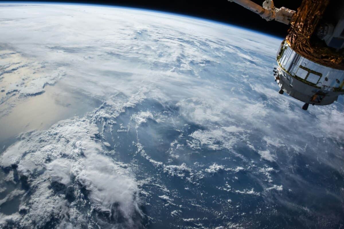 Satellite orbiting above the cloud-covered surface of Earth